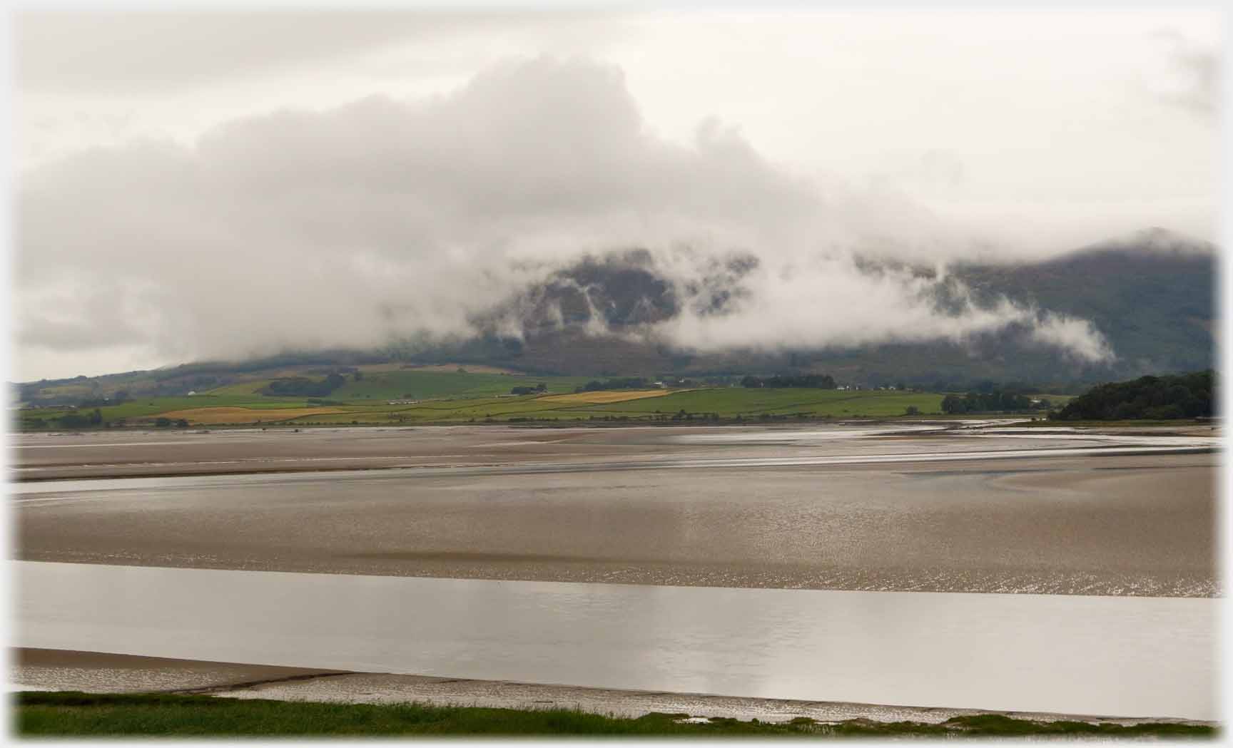 Broken wispey cloud on hillside.