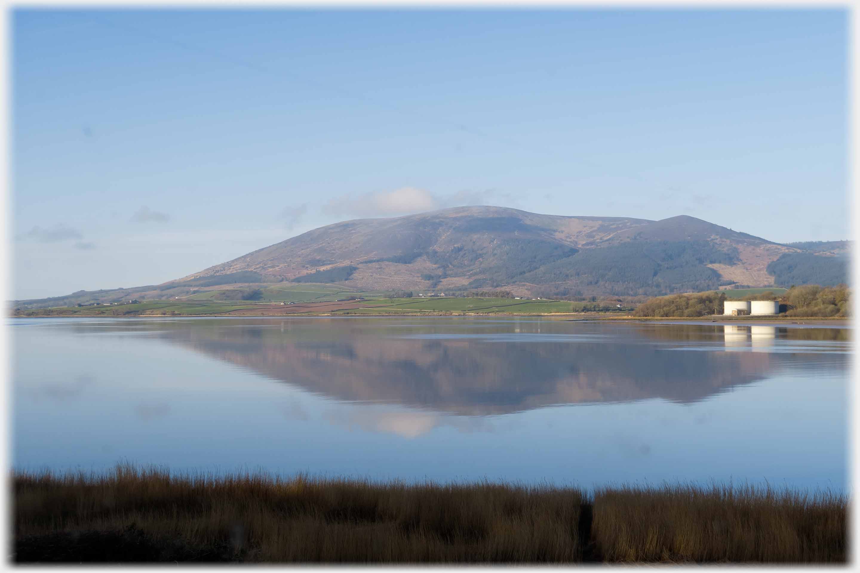 Hill reflected in still water.