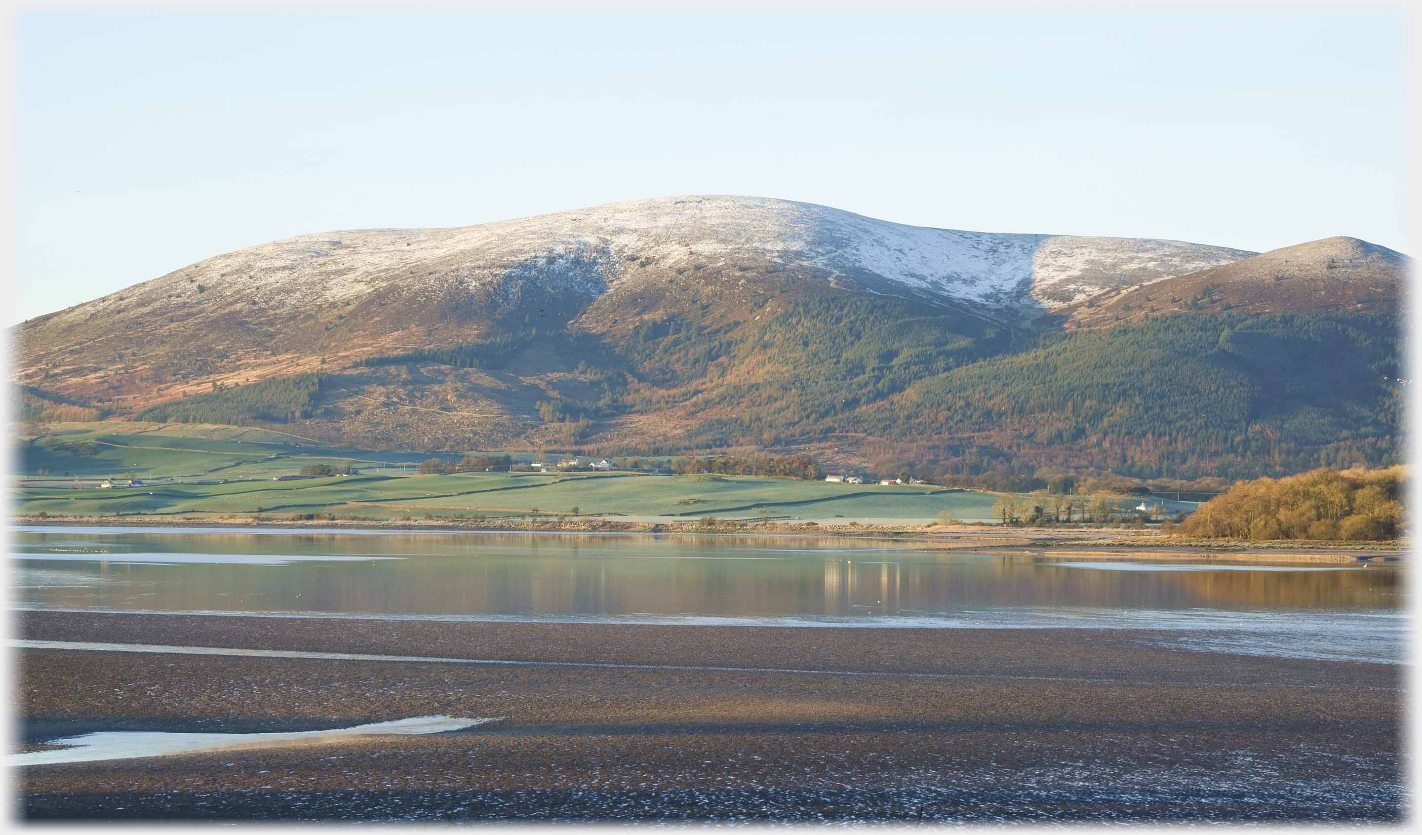 Gentle sun on hill with slight snow capping.