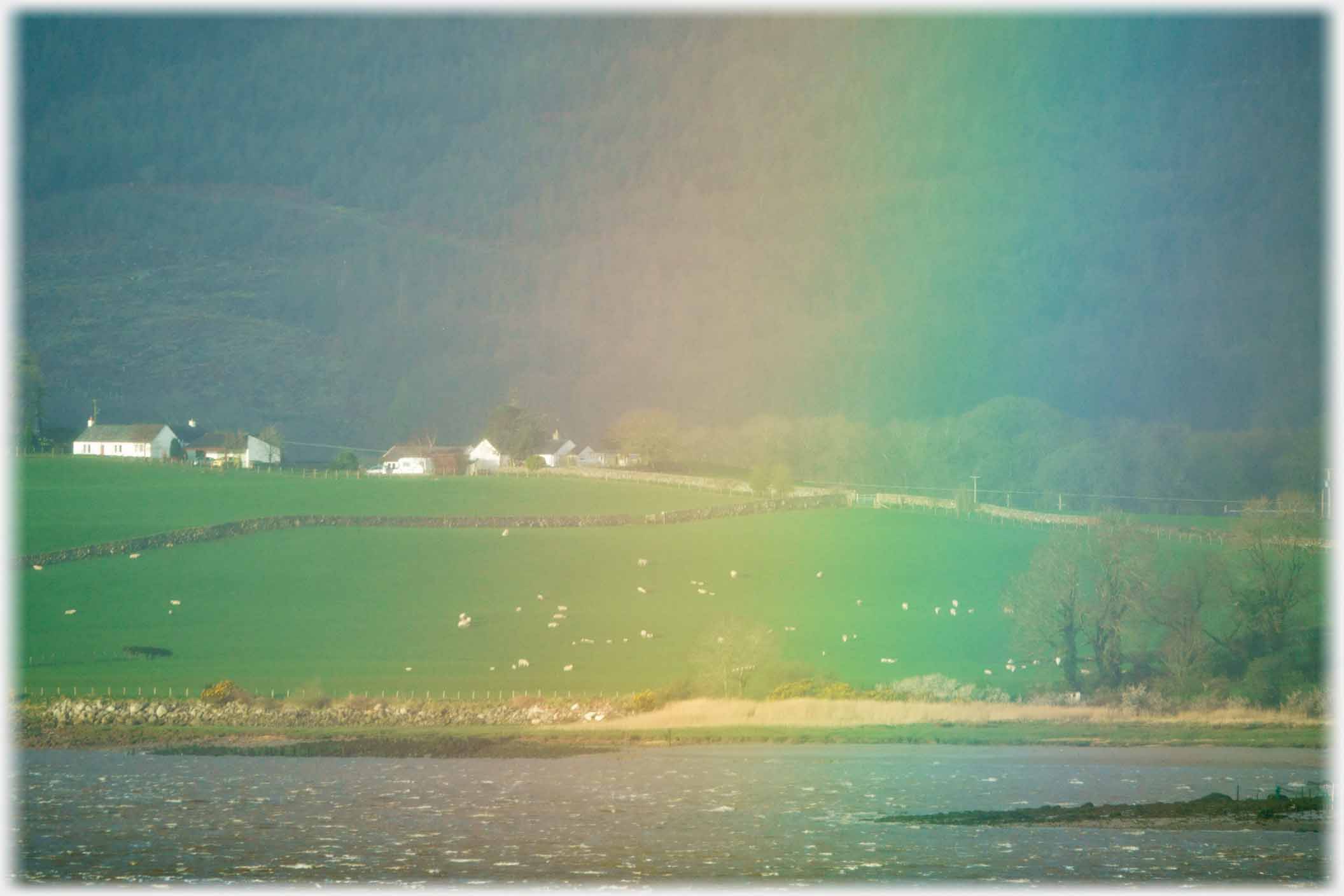 Buildings and field throough rainbow of light.