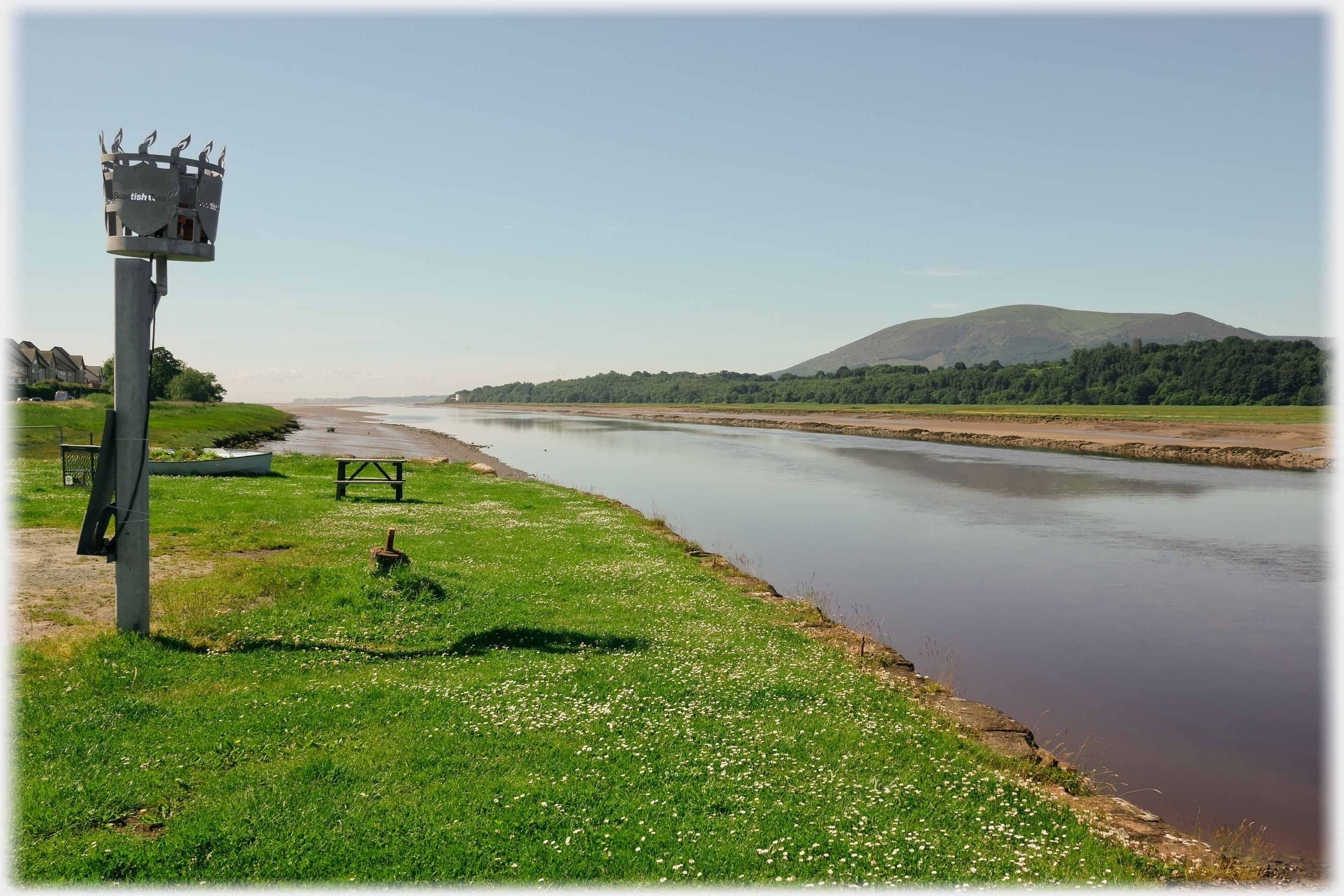 Brazier on pole, river and hill.