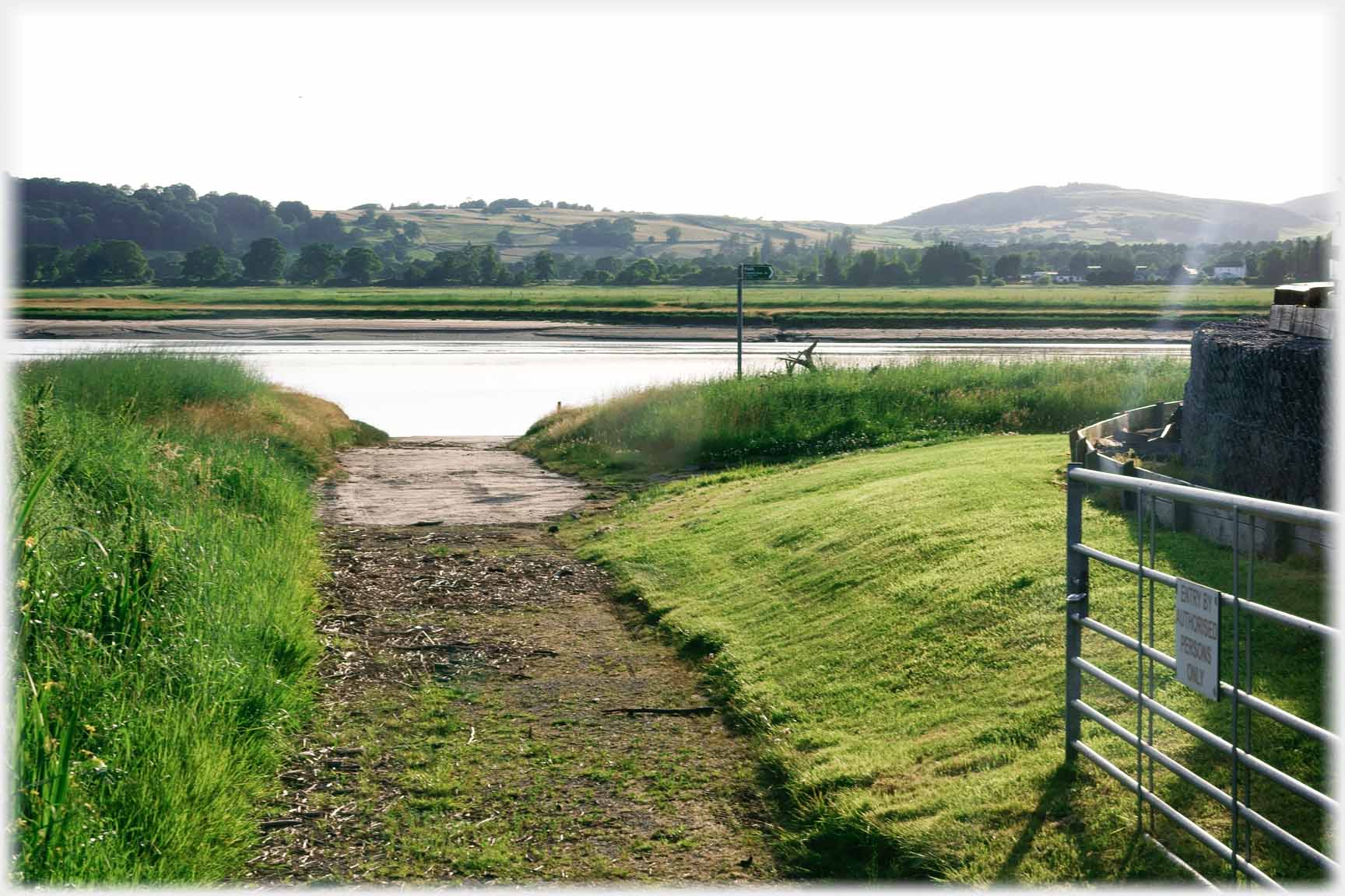 Drive leading down to river through gate.