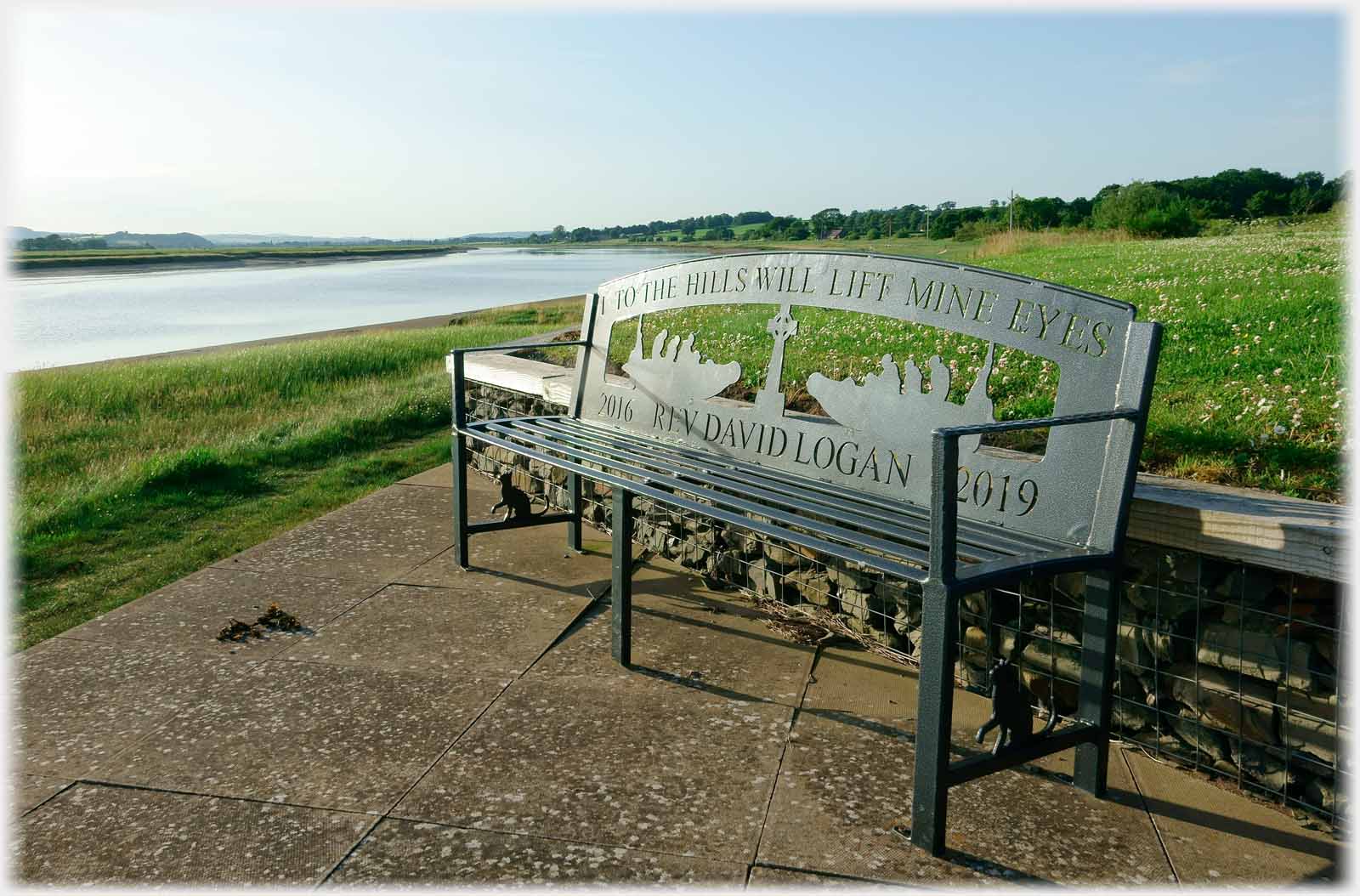 A metal bench with complex back showing life boats.