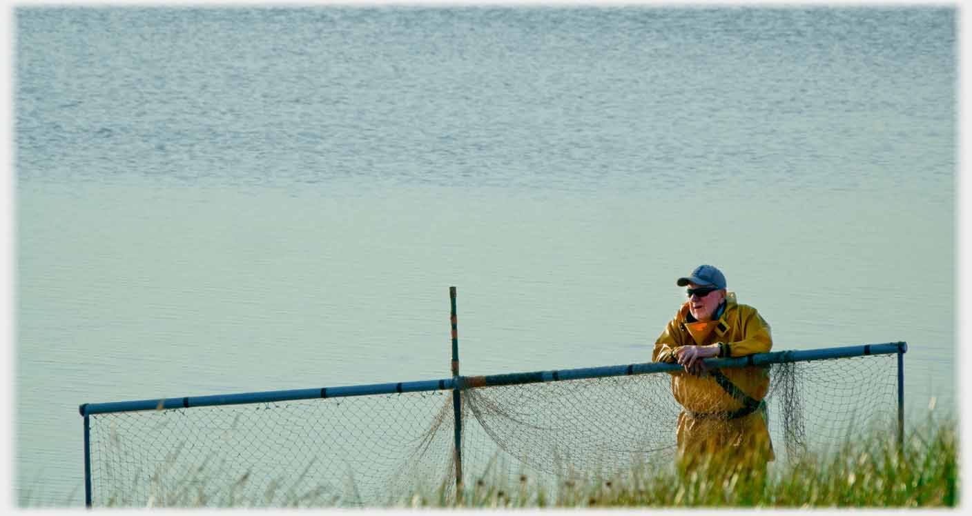 Man leaning on framed net.