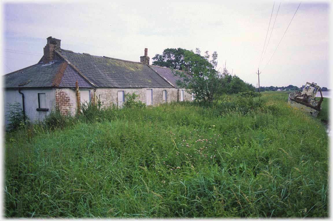 Boarded up pair of cottages.