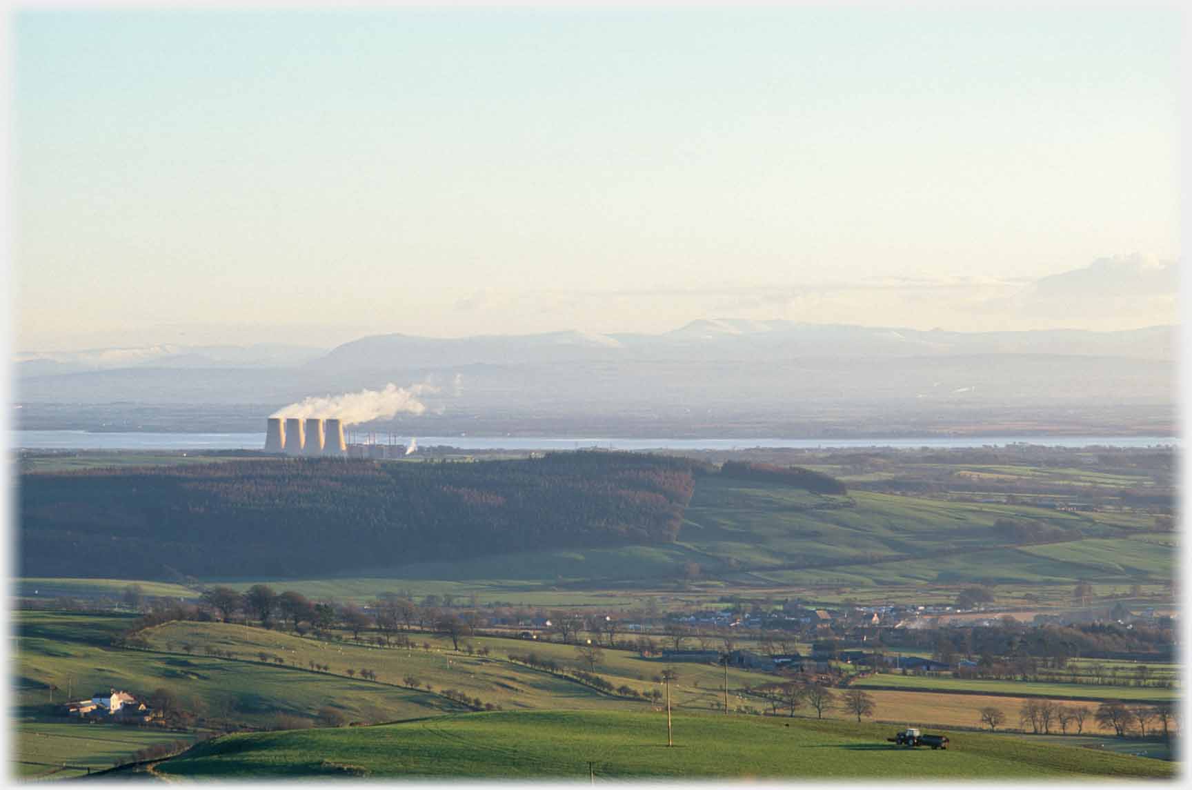 Four cooling towers steaming, 2 or 3 miles away.