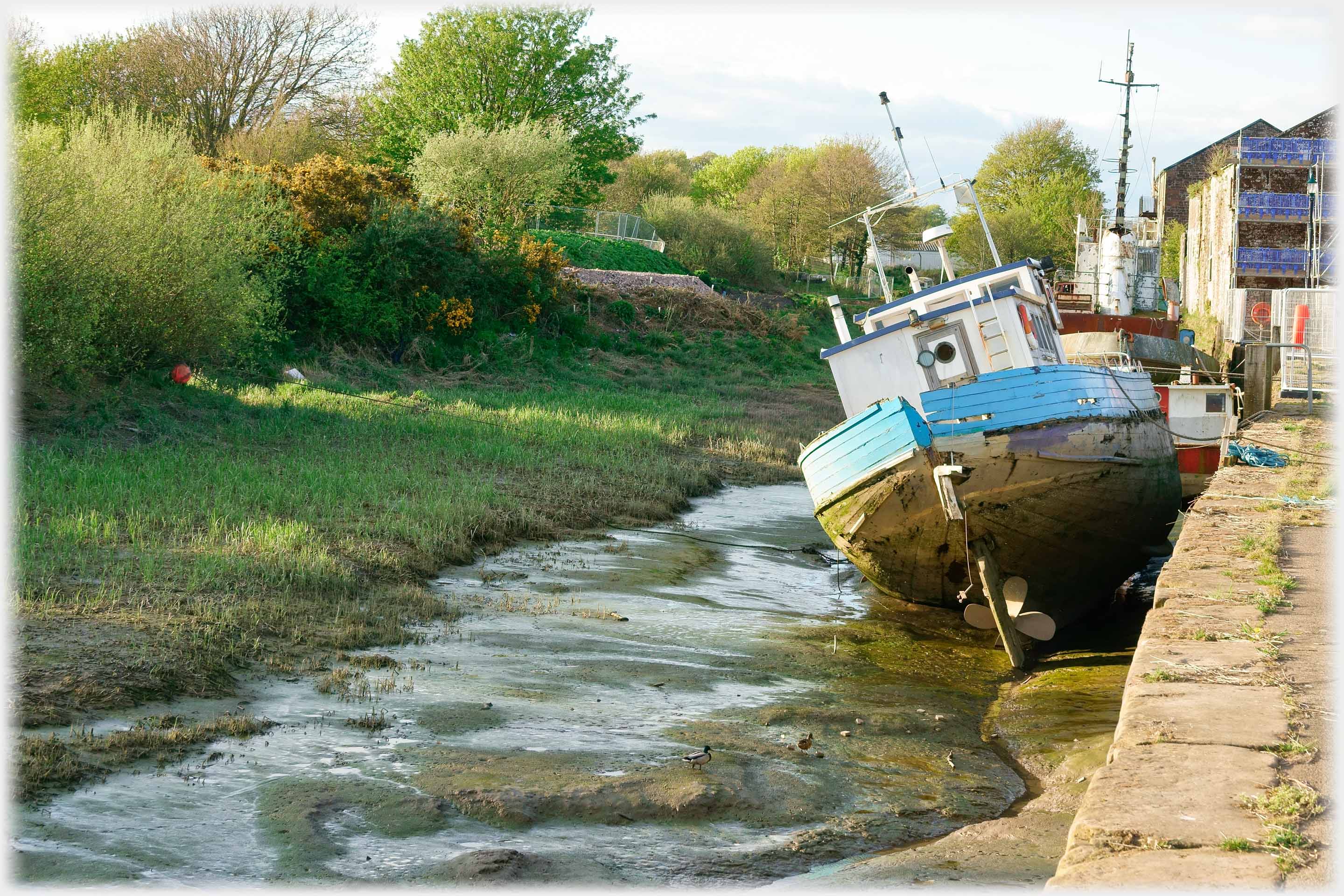 Boat on mud by queue.