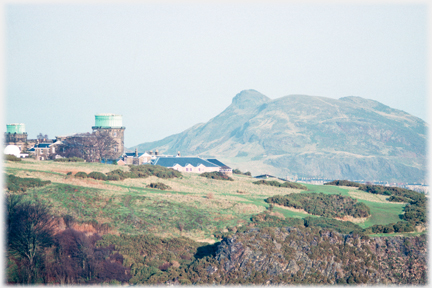 Cylindrical building and rough ground, Arthur's seat beyond.