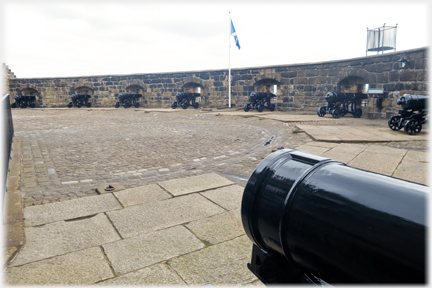 Curved wall with cannons set along it.