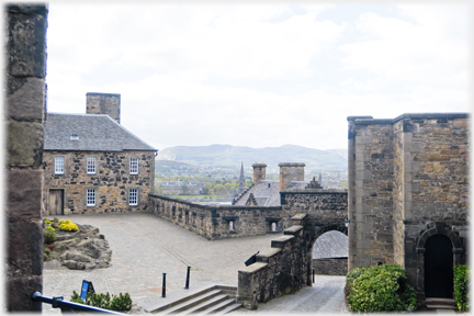 Castle buildings with hills in the distance.