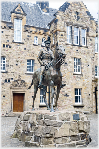 Horseman on plinth, building behind.