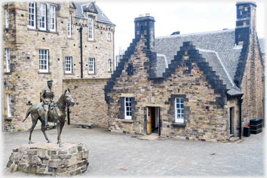 Horseman beside crow-stepped gabled building.