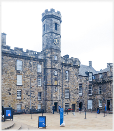 Courtyard of buildings with slim tower at centre.