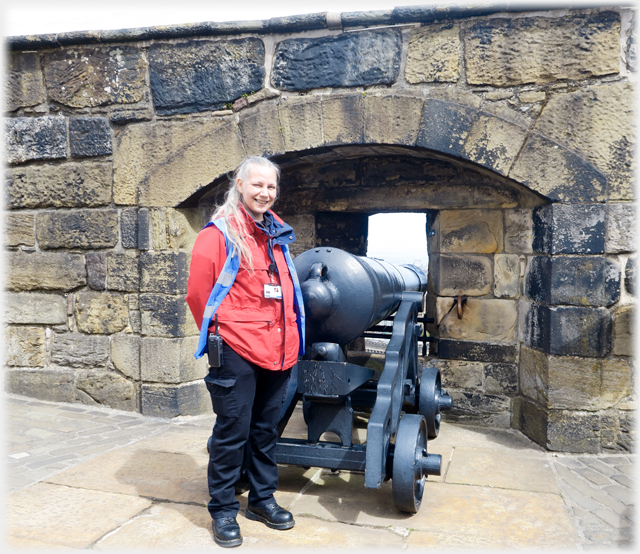 'Terry' in red jacket standing in front of black cannon.