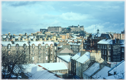 Rooftops and castle in snow and sun.