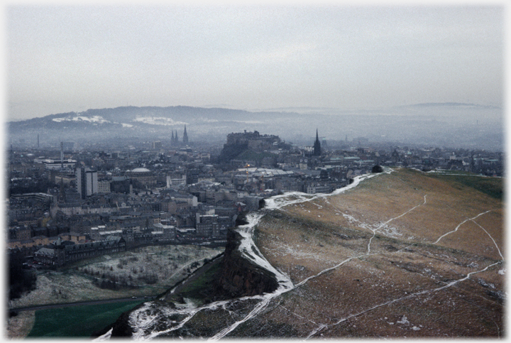 Castle with city around it, snow marked foreground.