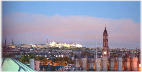 City centre with chimney pots and brightly lit castle.