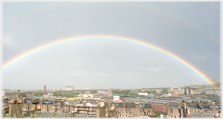Rainbow arched over townscape.