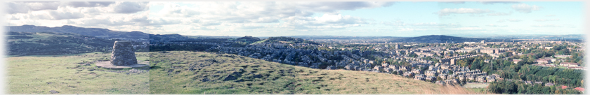 Four frames joined with hill in foreground and houses beyond.