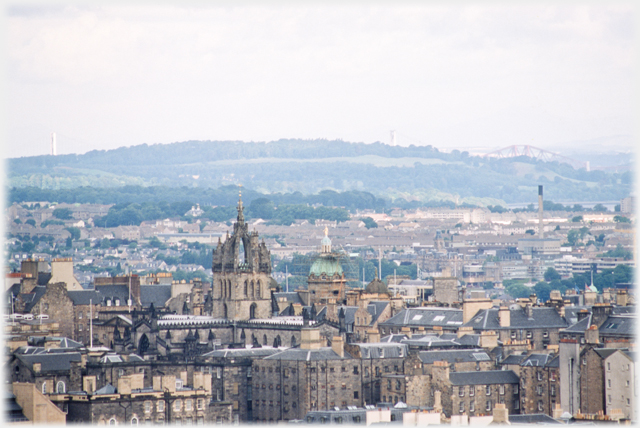 City rooftops with hill beyond.