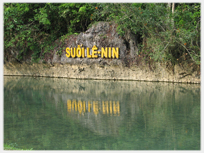 Large words on a rock above a river.