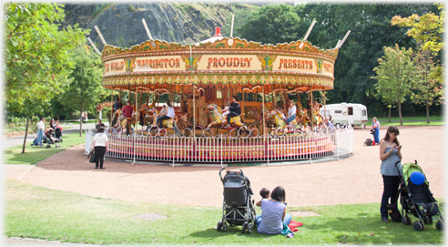 Brightly coloured roundabout with painted words.