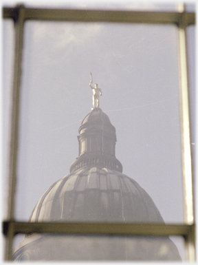 Windowpane framing dome with golden figure on top.