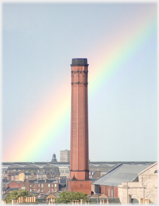 Large factory chimney with rainbow