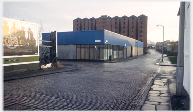 Warehouse, cobbled street, billboard.