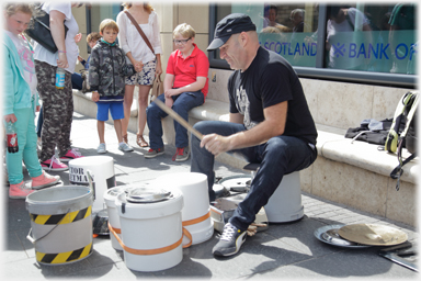 Drummer with range of buckets and containters.