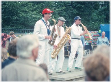 Three brass instramentalists playing in line.