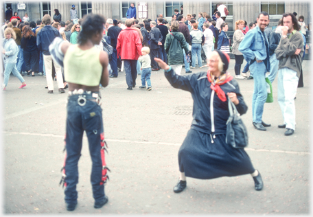 Woman in woolly hat sparring with entertainer.