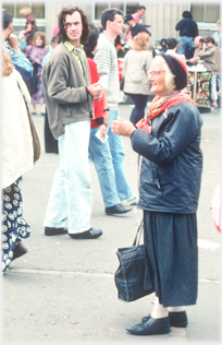 Woman in woolly hat standing.