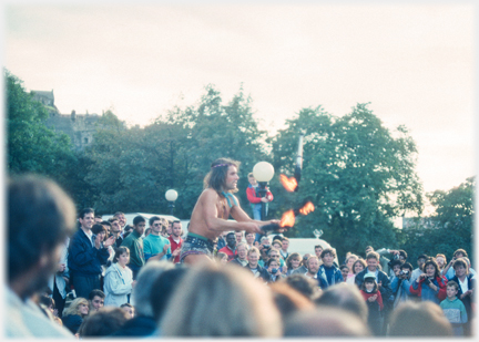 Man juggling three lit torches.