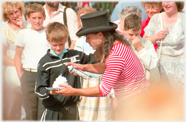 Performer squerting foam onto a plate held by a volunteer.