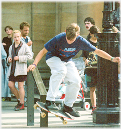 Skate boarder being watched by  a girl.
