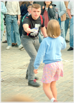 Man offering leaflet to girl.