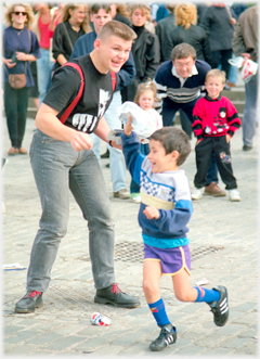 Boy runs past the man and snatches a leaflet.