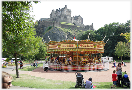 Merry-go-round in space with castle on rock behind it.