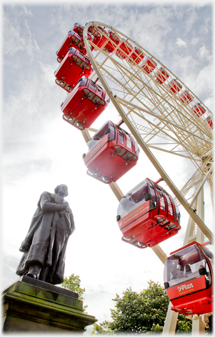 Same statue with more of the ferris wheel visible.