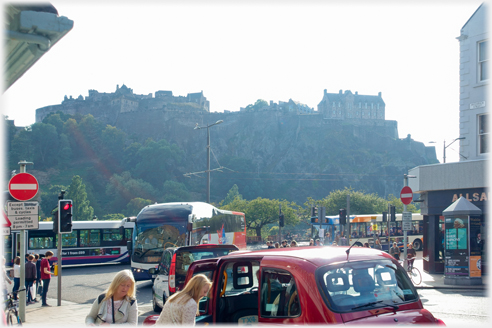 Castle beyond traffic and taxi loading.