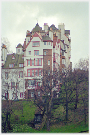 Eight story complex building with trees in front.