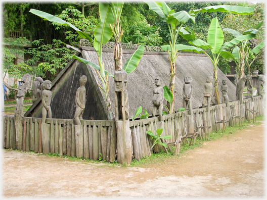 Triangular section building with perimiter wall on which are naked human figures.