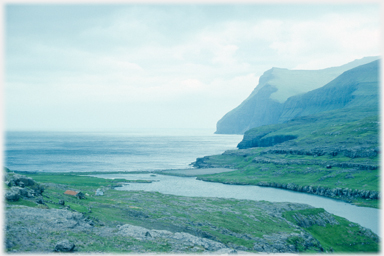 Hut, river and cliffs.