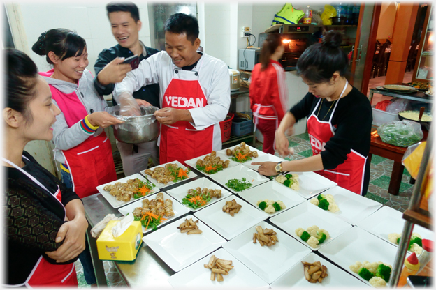 Staff arranging food on plates.