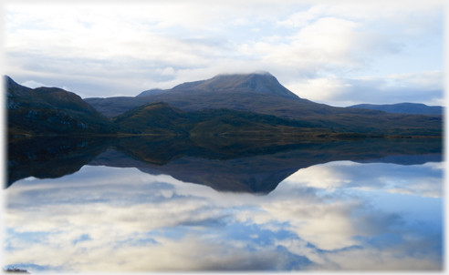 Hill across loch with cloud on top.