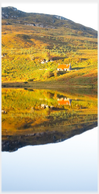 Loch with figure and steep hills on far shore.