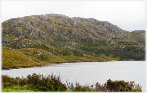 Moorland with house and distant hills.