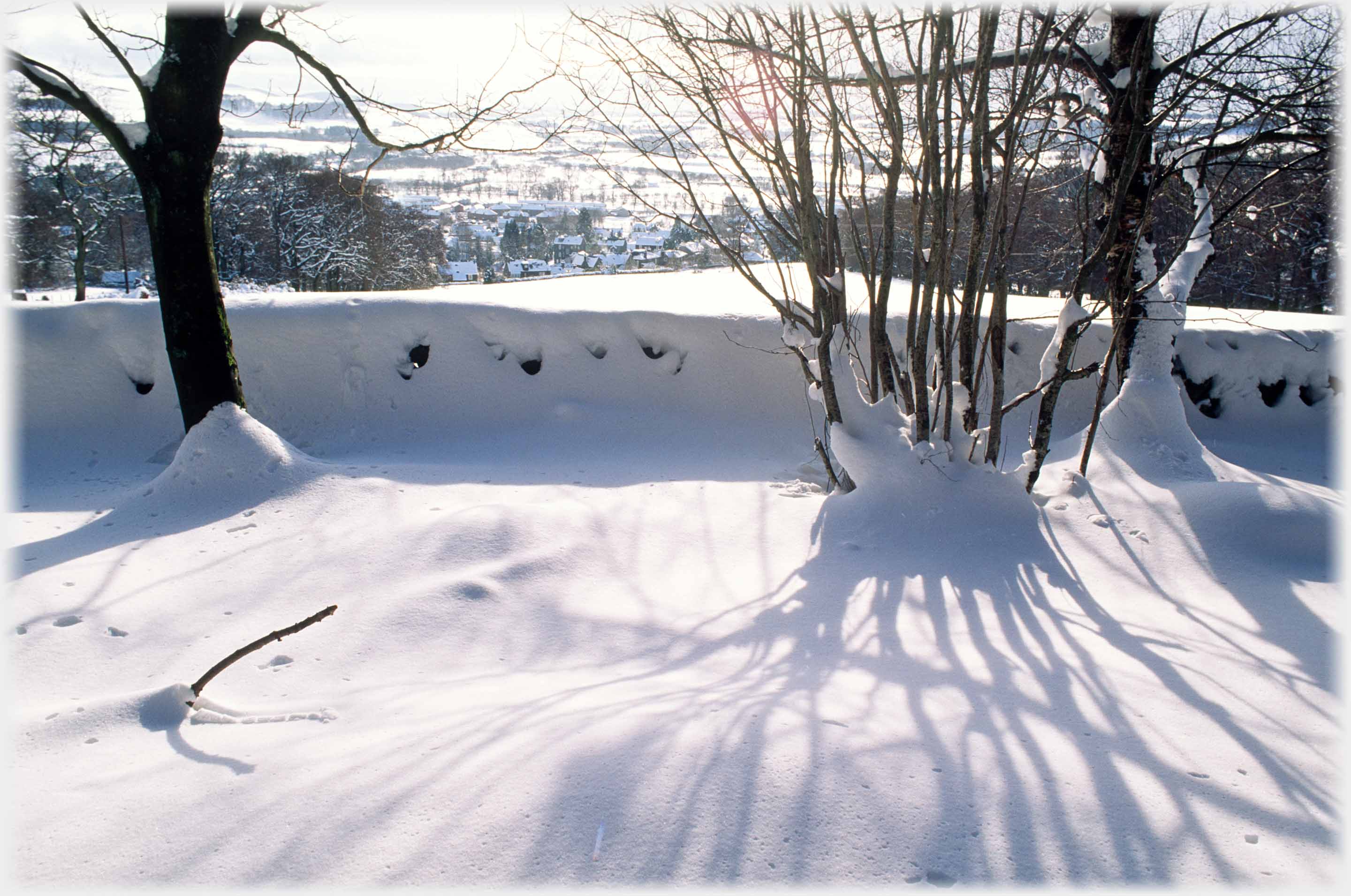 Fields dropping down to house, bracken covered hillsides rising to far hills.