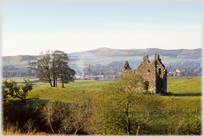 Ruined tower house with hill in distance.